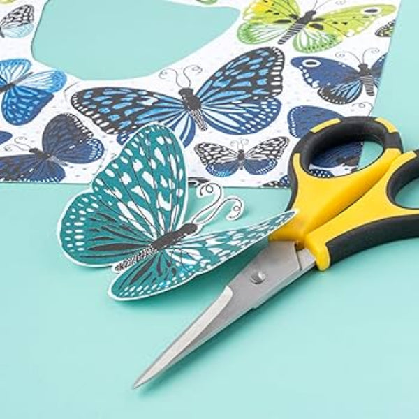 Butterfly cutouts with a pair of scissors on a light blue background