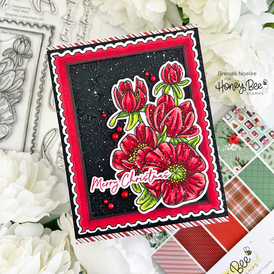 Christmas-themed card with red flowers and 'Merry Christmas' text, surrounded by floral decorations and stamping materials.