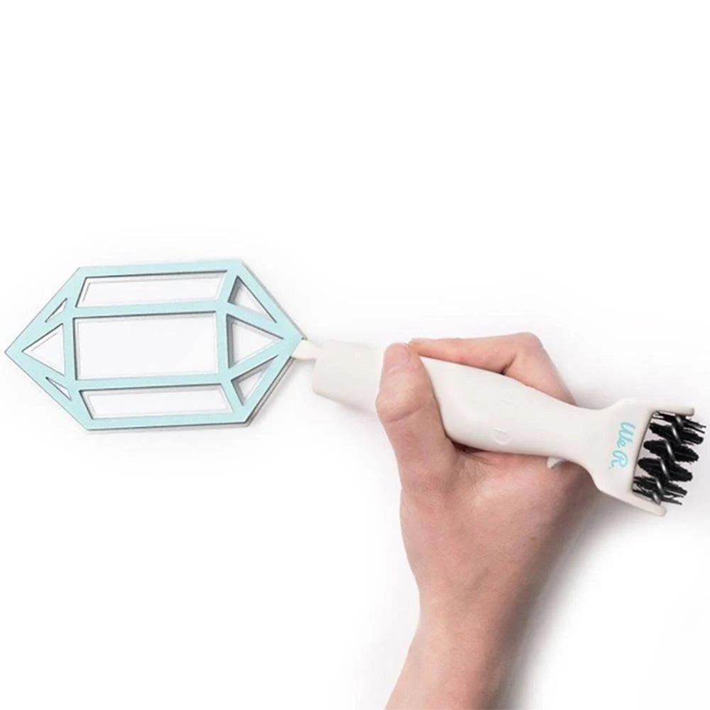 Hand holding a cleaning brush with geometric design on a white background