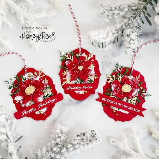Three red handmade Christmas tags with floral embellishments and holiday greetings