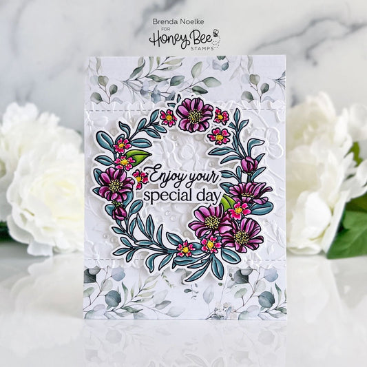 Handmade card featuring a floral spring wreath with purple flowers and 'Enjoy your special day' text.
