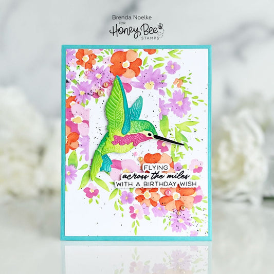 Handmade birthday card featuring a 3D green hummingbird and colorful watercolor flowers.