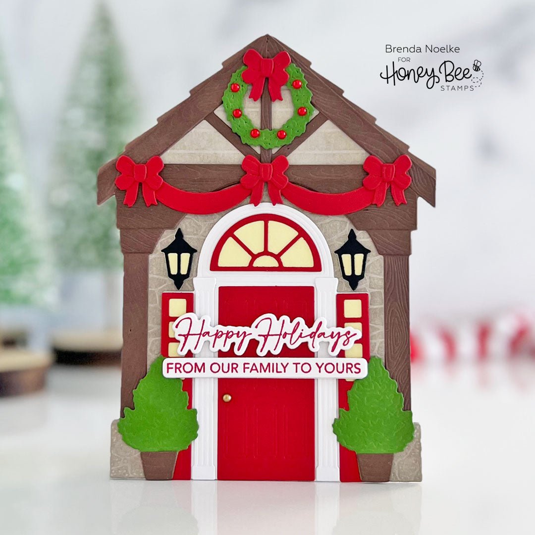 Handmade holiday card featuring a house front porch with a red door and Christmas decorations.