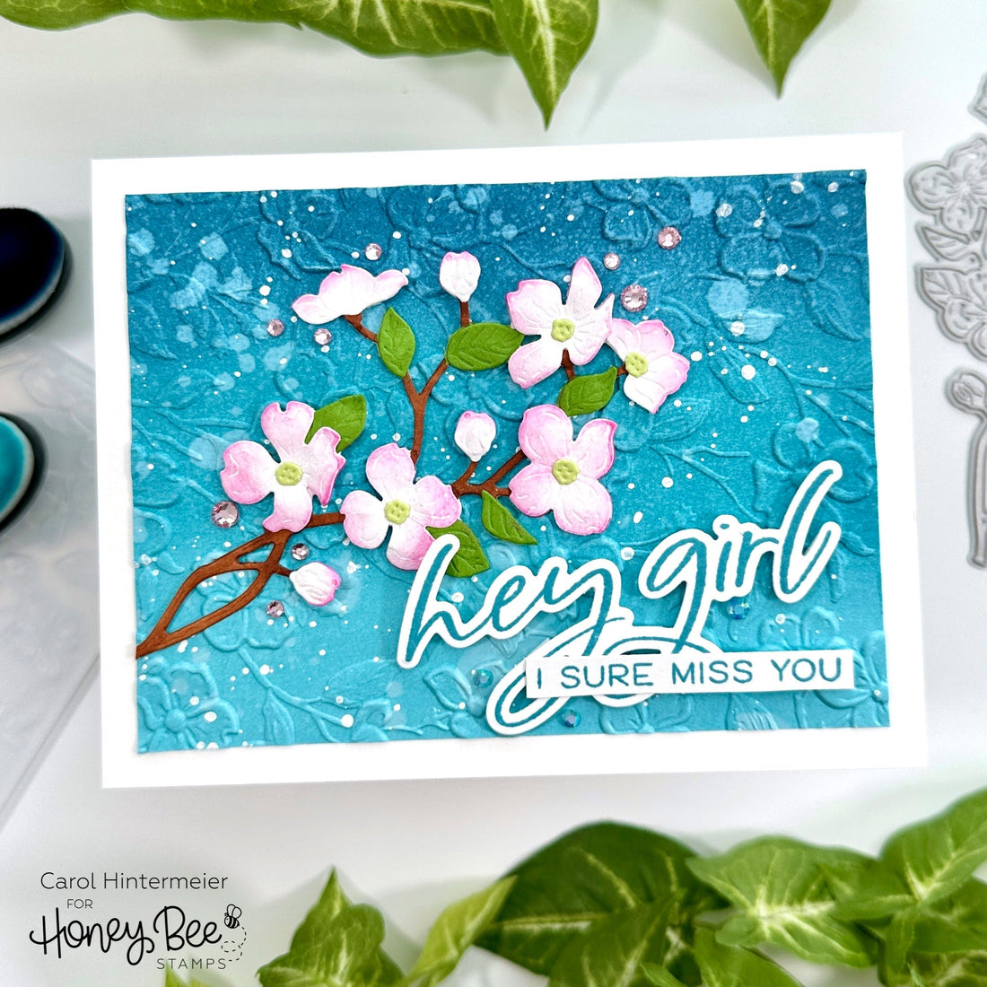 Handmade card with teal textured background, pink floral die cuts, and 'hey girl' sentiment.