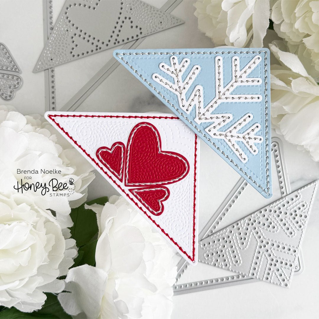 Handmade triangular corner bookmarks with red hearts and a blue snowflake design.