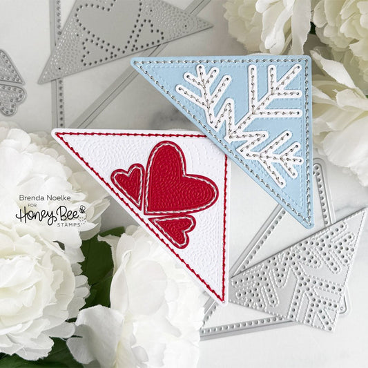 Handmade triangular corner bookmarks with red hearts and a blue snowflake design.