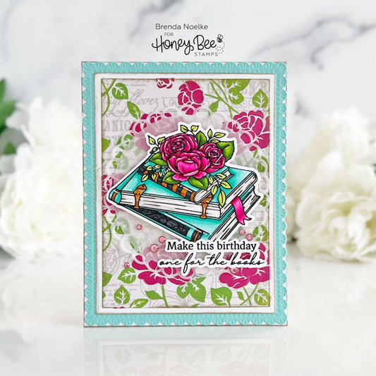 Handmade birthday card featuring a stack of teal books with pink roses and floral background.