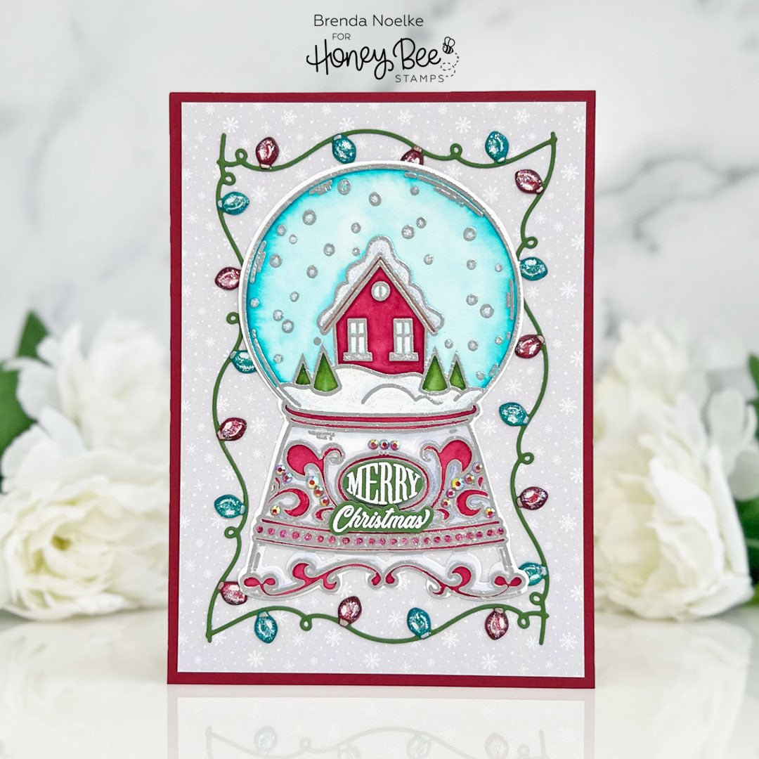 Handmade Christmas card featuring a 3D snow globe with a red cottage and 'Merry Christmas' text.