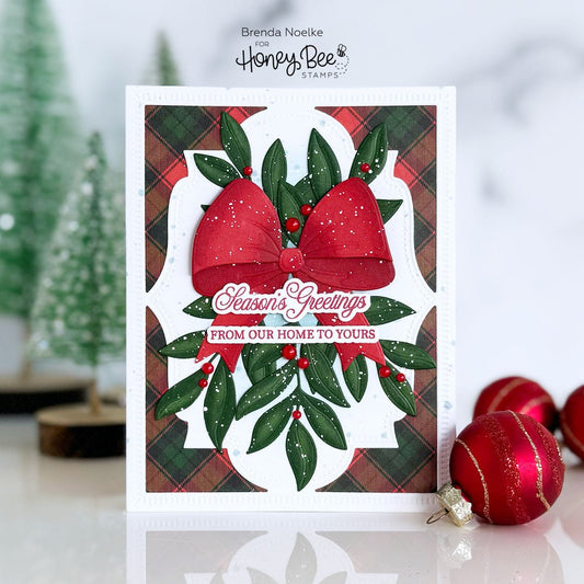 Handmade Christmas card with a red bow, green leaves, and 'Season's Greetings' text.