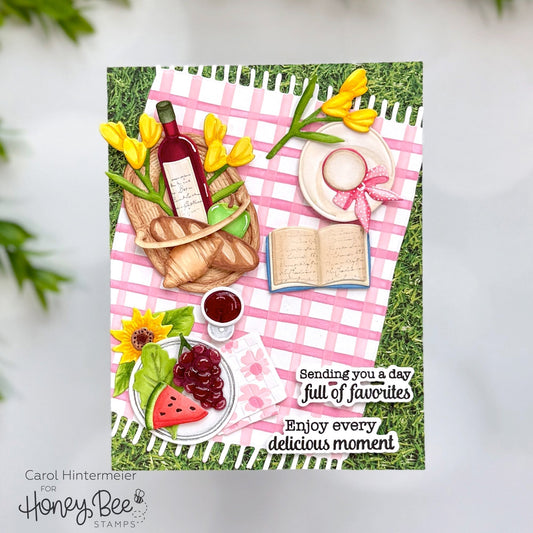 Handmade card featuring a 3D picnic scene with food, wine, and a book on a pink checkered cloth.
