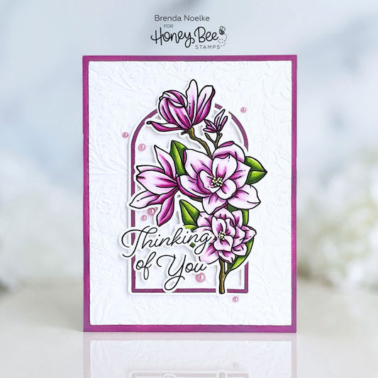 Handmade 'Thinking of You' card with pink magnolia flower stamps and embossed white background.