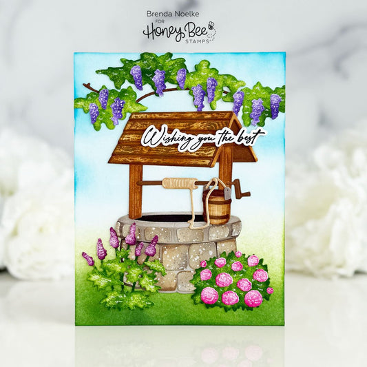 Handmade greeting card featuring a 3D wishing well with purple flowers and 'Wishing you the best' text.