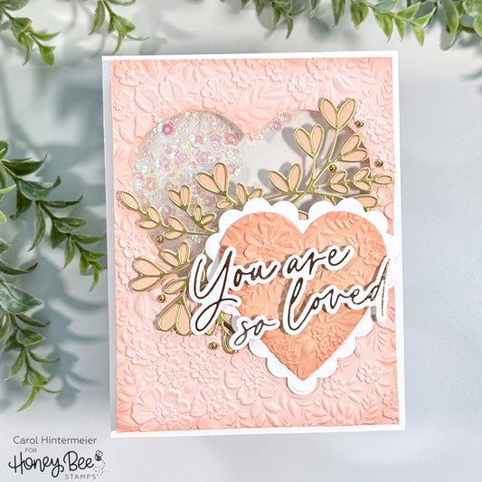 Peach shaker card with a 3D embossed heart and 'You are so loved' gold foil lettering.