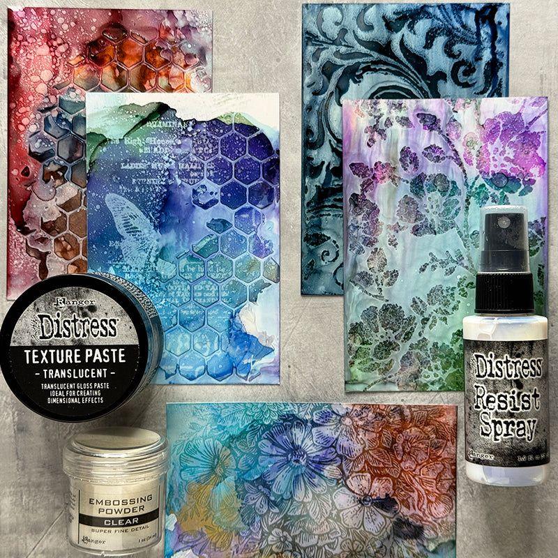 Collection of art supplies including Texture Paste, Resist Spray, and Embossing Powder on a textured surface.