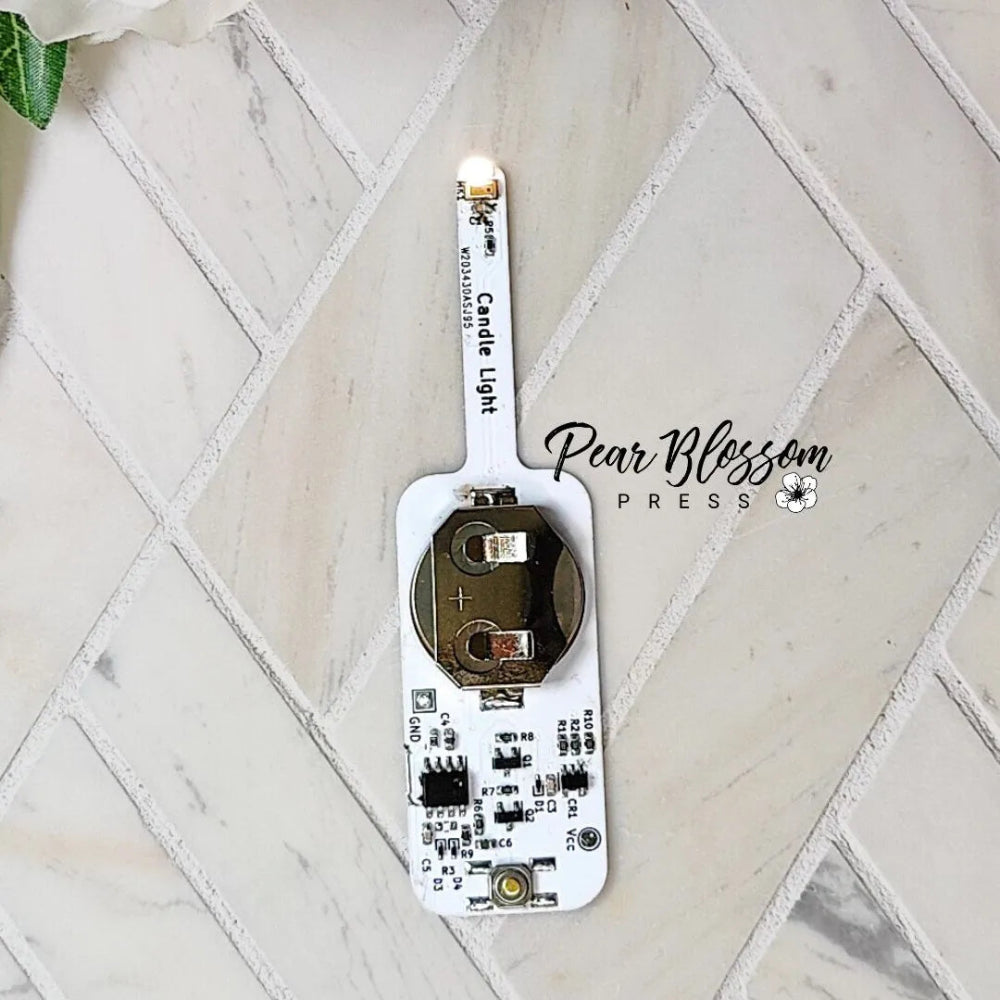 Electronic component on a marble surface with 'Pear Blossom Press' branding.