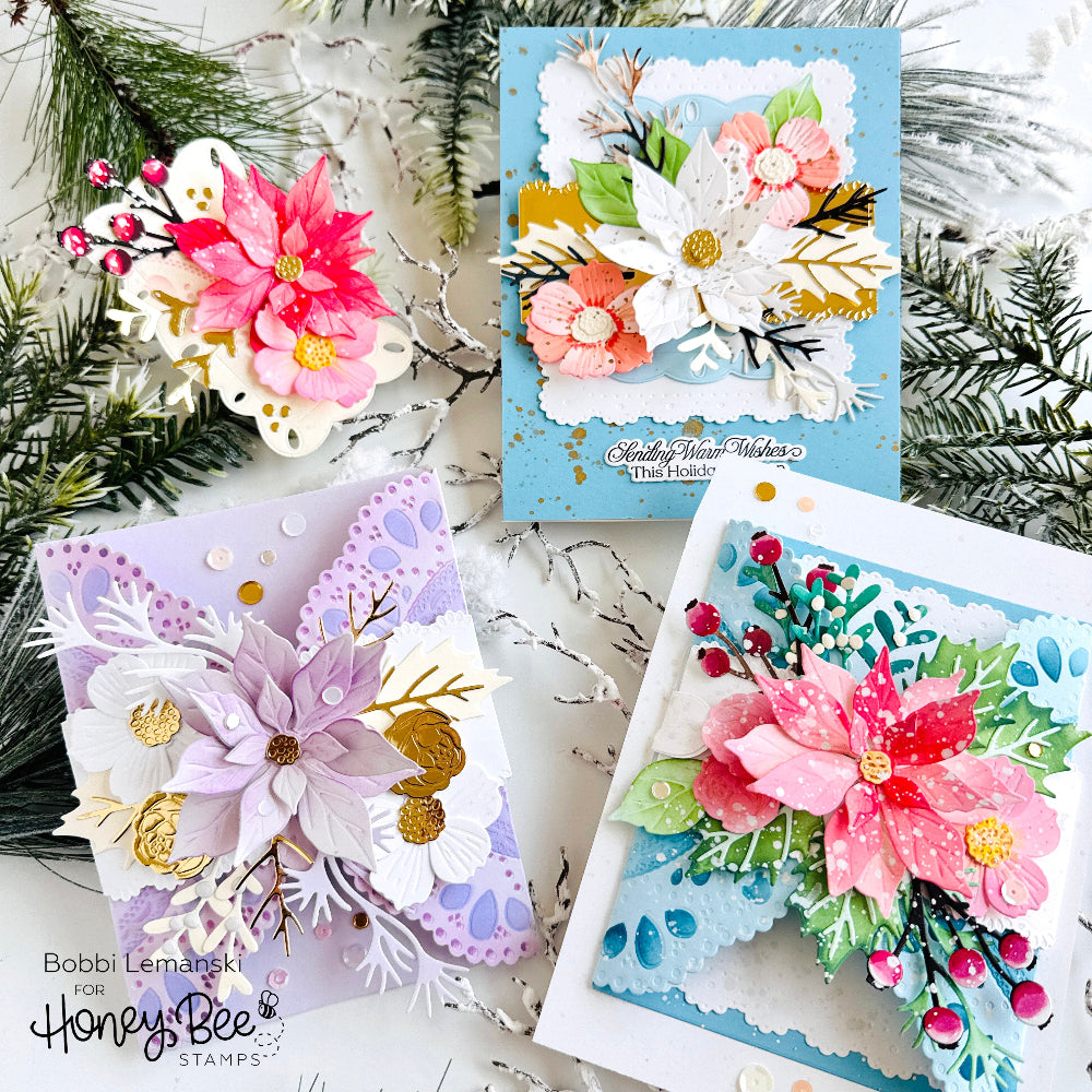 Three handmade floral cards arranged on a snowy white surface with pine branches. The cards feature layered paper flowers, snowflakes, and berries in pastel and bright colors, with one card reading 'Holiday Honeysuckle That Blooms'.