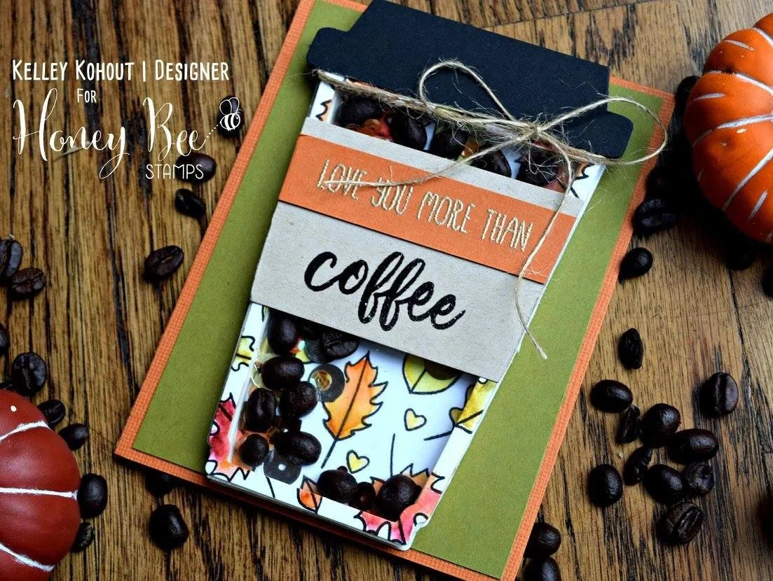 Card with coffee-themed design on a wooden surface with pumpkins and coffee beans.