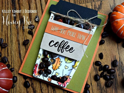 Card with coffee-themed design on a wooden surface with pumpkins and coffee beans.
