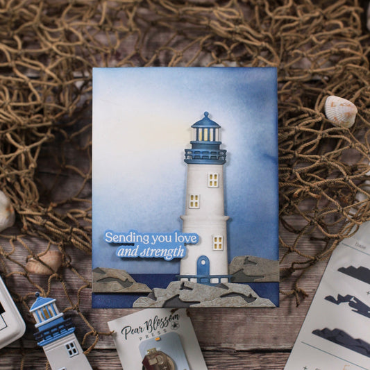 Card with a lighthouse design and text 'Sending you love and strength' on a textured surface.
