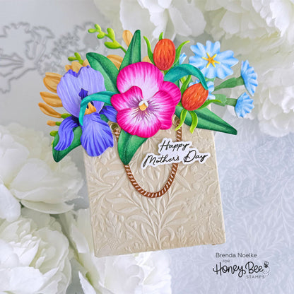 Colorful floral arrangement on a card with 'Happy Mother's Day' text, surrounded by white flowers.