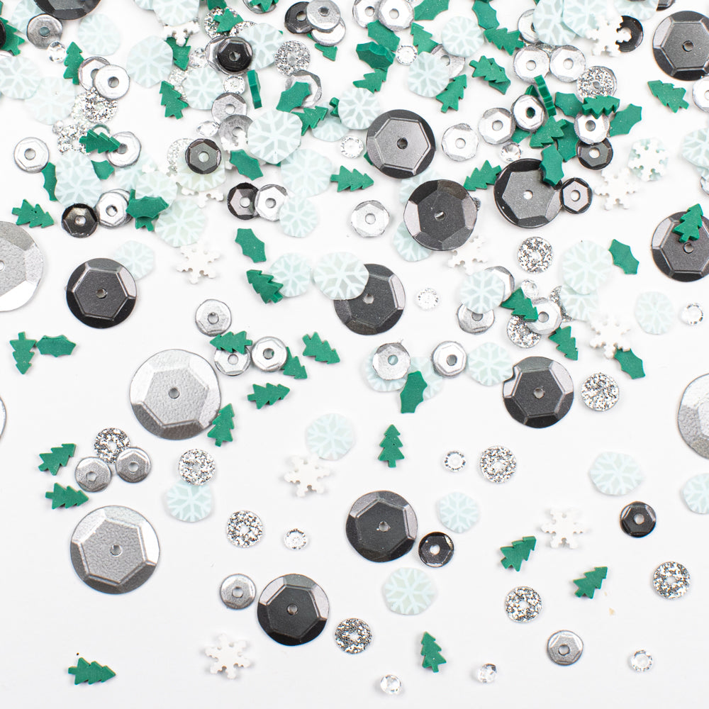 Assorted decorative elements including silver hexagons, green trees, and white flowers on a white background