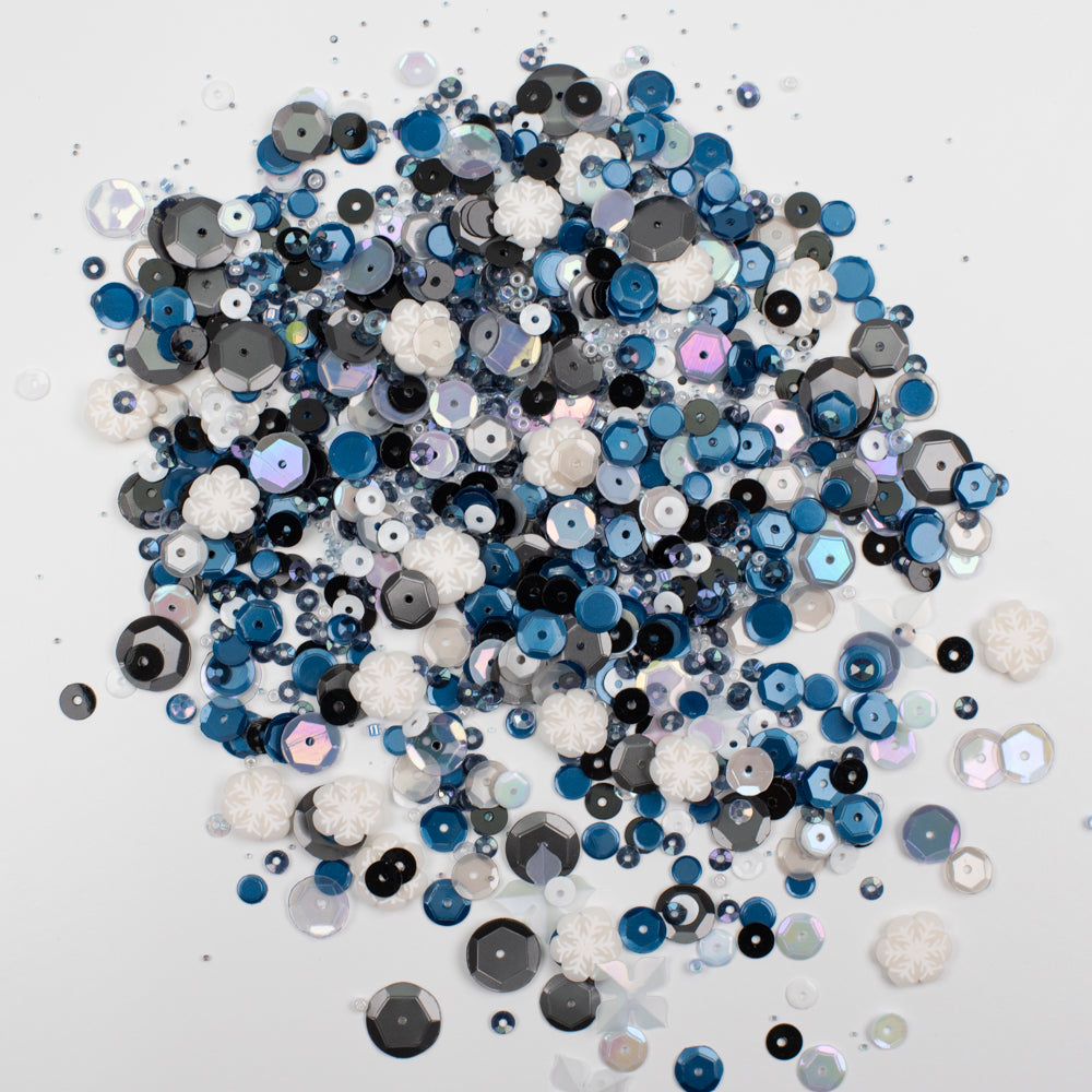 Assorted blue, black, and white sequins on a white background