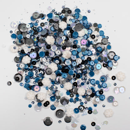 Assorted blue, black, and white sequins on a white background