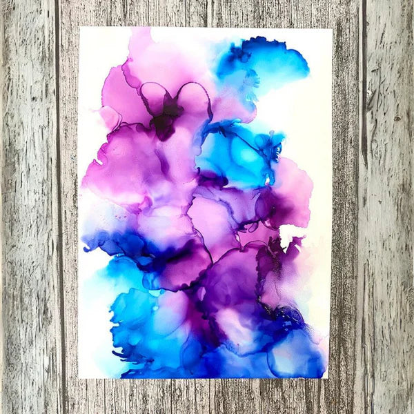 Abstract art print with purple and blue floral design on a wooden surface