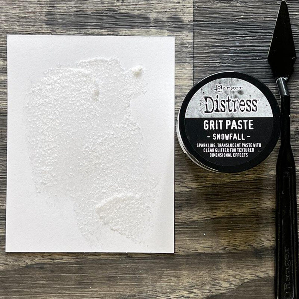 Distress Grit Paste container with a textured white surface on a wooden background